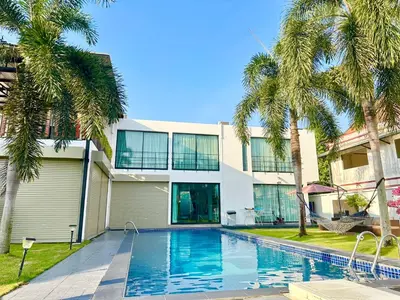 a villa with a swimming pool and palm trees at The White House Kamala Phuket in Kamala Beach