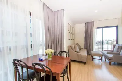 a living room with a wooden table and chairs at DLUX Condominium Chalong Phuket in Ban Klang