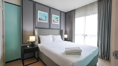 a bedroom with a large bed and a large window at DLUX Condominium Chalong Phuket in Ban Klang