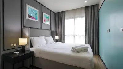 a hotel room with a bed and a window at DLUX Condominium Chalong Phuket in Ban Klang