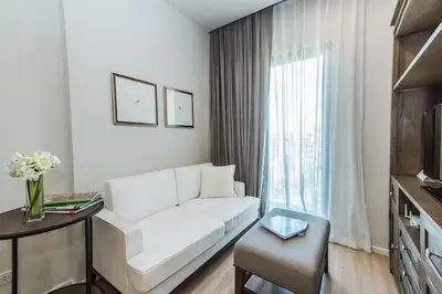 a white living room with a white couch and a window at DLUX Condominium Chalong Phuket in Ban Klang