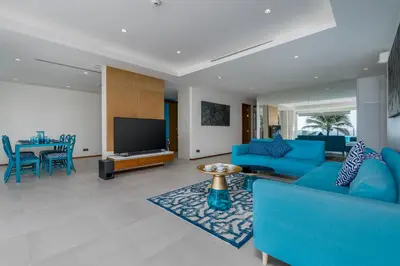 a living room with blue furniture and a flat screen tv at WEG Elite Beachfront in Phuket Town
