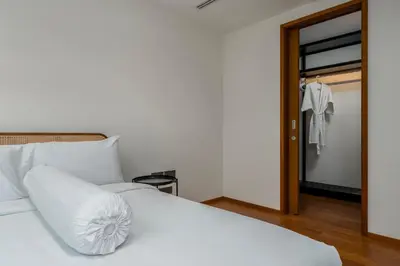 a white bed with a pillow on top of it at WEG Elite Beachfront in Phuket Town