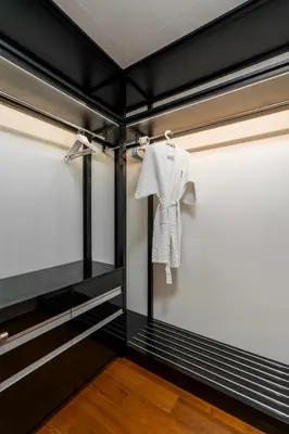 a white shirt hanging on a rack in a room at WEG Elite Beachfront in Phuket Town