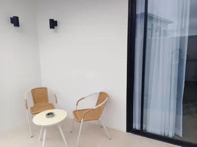 two chairs and a table next to a window at Rapina House in Mai Khao Beach