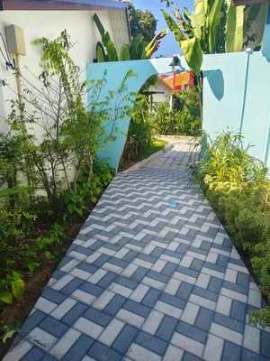 a cobblestone path in front of a house at Rapina House in Mai Khao Beach