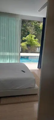 a bedroom with a bed with a view of a pool at Kamala Falls Seaview 2 bedroom in Kamala Beach