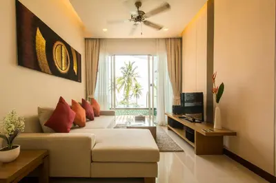 a living room with a couch and a television at Krabi Seaview Penthouse in Klong Muang Beach
