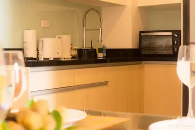 a kitchen with a microwave and a table with food at Krabi Seaview Penthouse in Klong Muang Beach