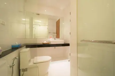 a white bathroom with a toilet and a sink at Krabi Seaview Penthouse in Klong Muang Beach