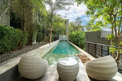 a swimming pool with two chairs and a table at 2BR Pavilion near Kamala Beach, Natural Park P10 in Kamala Beach
