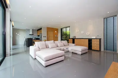 a living room with a white couch and a kitchen at 2BR Pavilion near Kamala Beach, Natural Park P10 in Kamala Beach