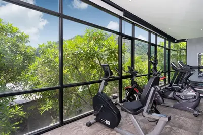 a gym with a row of exercise bikes in a room with windows at 2BR Pavilion near Kamala Beach, Natural Park P10 in Kamala Beach