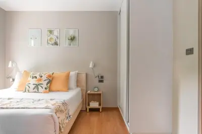 a white bedroom with a bed with orange pillows at Title V Lemon Fresh Pool View Gym Hammam in Rawai Beach