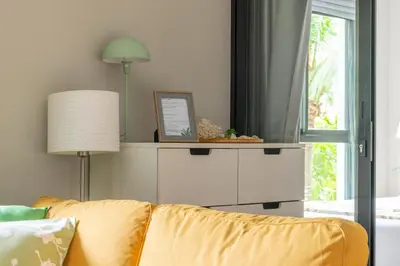 a living room with a yellow couch and a window at Title V Lemon Fresh Pool View Gym Hammam in Rawai Beach