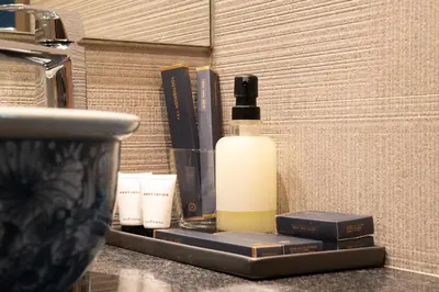 a bottle of soap and books on a counter at Title V Lemon Fresh Pool View Gym Hammam in Rawai Beach