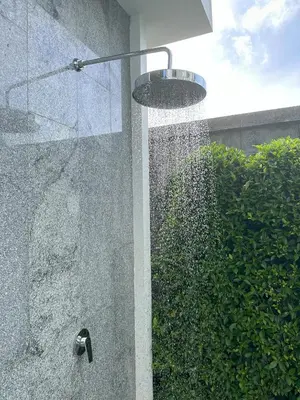 a shower with a water fountain in front of a bush at Title V Lemon Fresh Pool View Gym Hammam in Rawai Beach