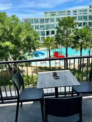 a table and chairs on a balcony with a view of a pool at Duplex in a 5 star hotel La Vita in Phuket Town