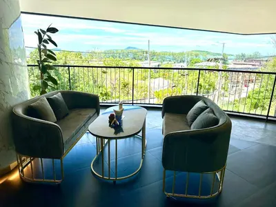 two chairs and a table in a room with a balcony at Duplex in a 5 star hotel La Vita in Phuket Town