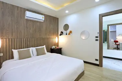 a bedroom with a white bed and a tv at 2 bdr Apartment Calypso Garden NaiHarn Beach by Capital Pro CGC-310 in Rawai Beach