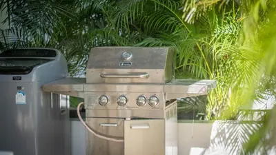 a stove and a trash can next to a palm tree at Recently renovated 3BR apartment near Layan Beach in Phuket Town