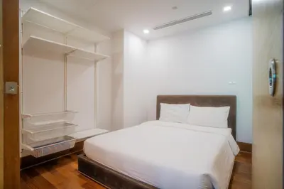 a bedroom with a white bed and a closet at Modern Beachfront Apartment Naithon Beach in Nai Thon Beach