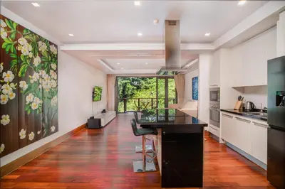 a kitchen with a large painting on the wall at Modern Beachfront Apartment Naithon Beach in Nai Thon Beach