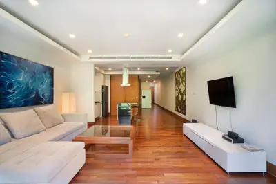 a living room with a couch and a tv at Modern Beachfront Apartment Naithon Beach in Nai Thon Beach