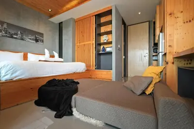 a bedroom with a large bed and a fireplace at 1bdr Apartment near NaiHarn beach by Capital Pro in Phuket Town