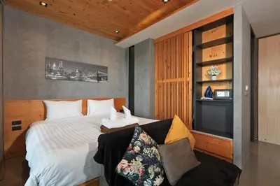a bedroom with a bed and a couch at 1bdr Apartment near NaiHarn beach by Capital Pro in Phuket Town