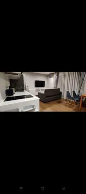 a living room with a couch and a table and chairs at Rawai The Title V 1BR in Rawai Beach