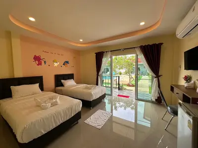 a bedroom with two beds and a sliding glass door at พัชรี รีสอร์ท ภูเก็ต Patcharee Resort Phuket in Phuket Town