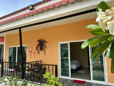a house with a balcony with a table and chairs at พัชรี รีสอร์ท ภูเก็ต Patcharee Resort Phuket in Phuket Town