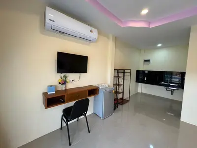 a room with a desk and a tv and a chair at พัชรี รีสอร์ท ภูเก็ต Patcharee Resort Phuket in Phuket Town