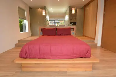 a bedroom with a bed with a red comforter at VILLA Pak Dang in Phuket Town