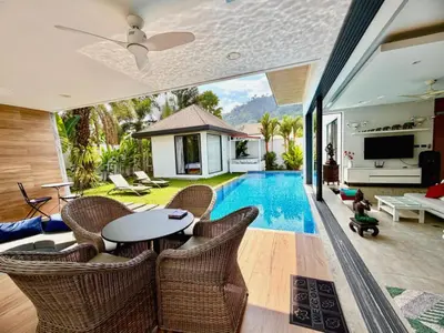 a living room with a table and chairs and a pool at VILLA Pak Dang in Phuket Town