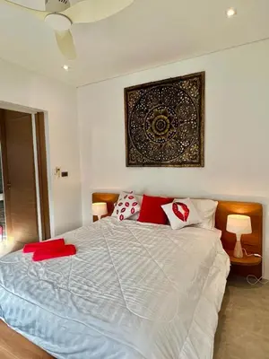 a bedroom with a large bed with red pillows at VILLA Pak Dang in Phuket Town