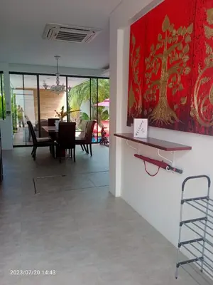a dining room with a table and a painting on the wall at VILLA Pak Dang in Phuket Town