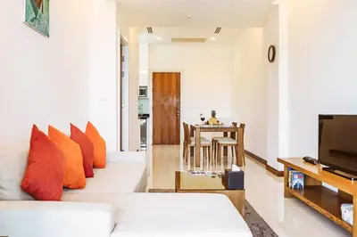 a living room with a white couch and orange pillows at Krabi One Bedroom Seaview in Klong Muang Beach