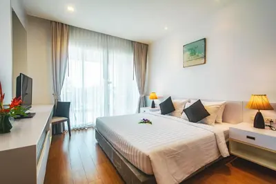 a hotel room with a large bed and a large window at Krabi One Bedroom Seaview in Klong Muang Beach
