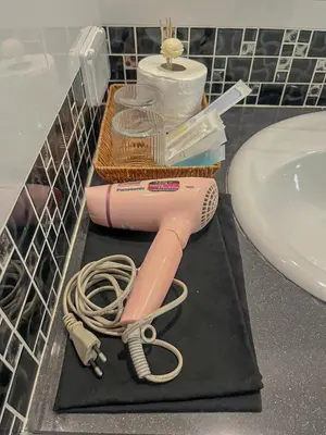 a pink hair dryer on a counter next to a sink at VK House Rawai, Phuket in Rawai Beach