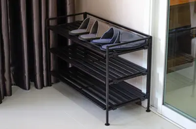 a black rack with shoes on it in a closet at VK House Rawai, Phuket in Rawai Beach