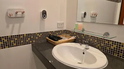 a bathroom with a sink and a basket on a counter at VK House Rawai, Phuket in Rawai Beach