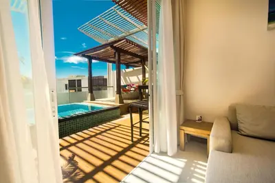 a balcony with a view of a pool and a couch at Krabi Luxury Penthouse in Klong Muang Beach
