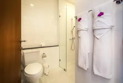 a bathroom with a toilet and a shower with towels at Krabi Luxury Penthouse in Klong Muang Beach