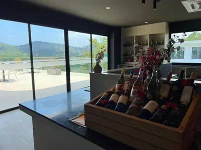 a bunch of wine bottles on a counter in a kitchen at Utopia Naiharn by Fred&Com Phuket in Rawai Beach