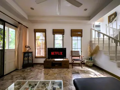a living room with a tv and a table at Mountain View Villa Kamala in Kamala Beach