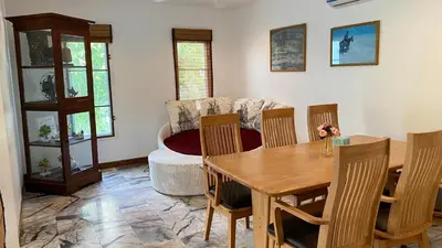 a living room with a table and chairs and a couch at Mountain View Villa Kamala in Kamala Beach
