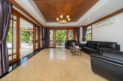 a living room with black leather furniture and a chandelier at Villa Aurora 4-bedroom Pool Villa in Kamala, Phuket in Kamala Beach