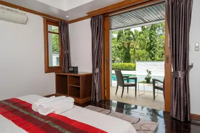 a bedroom with a bed and a view of a patio at Villa Aurora 4-bedroom Pool Villa in Kamala, Phuket in Kamala Beach